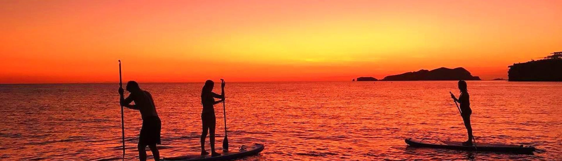 Die Tourteilnehmer genießen die wunderschönen Farben am Himmel während ihrer SUP Tour bei Sonnenuntergang in Ibiza mit Mediterrania Paddle Surf Ibiza. 