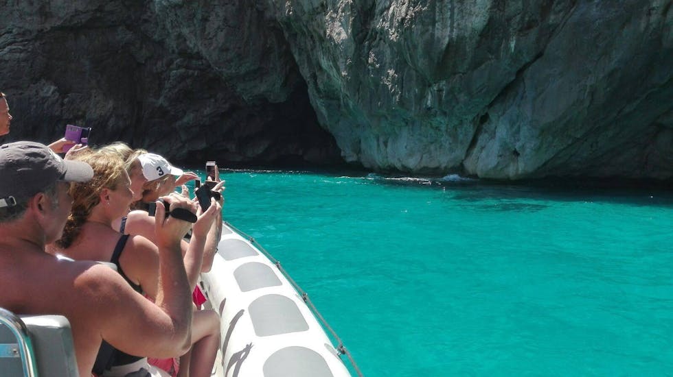 Die Tourteilnehmer genießen die Aussicht auf das glasklare Wasser und die Steinfelsen während der Bootstour zum Parc Natural de Llevant mit Schnorcheln mit Alcúdia Sea Explorer.