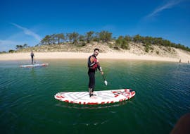 Two participants of the Private SUP Lessons at Lagoa de Albufeira in Sesimbra with Meira Pro Center Sesimbra are paddling in the calm water of the lagoon.