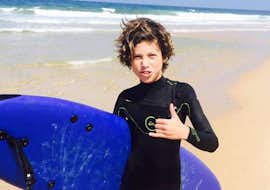 Privater Surfkurs an der Praia da Lagoa de Albufeira mit Meira Pro Center Sesimbra Ein Junge posiert während seines privaten Surfkurses an der Praia da Lagoa de Albufeira mit dem Meira Pro Center Sesimbra für ein Foto mit seinem Surfbrett.
