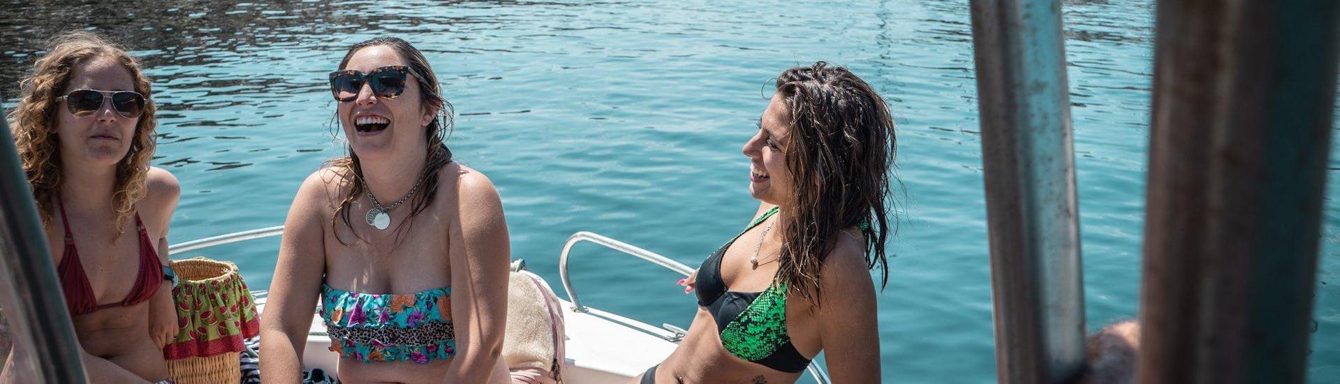 Drei Freundinnen genießen die Fahrt während der vom Meira Pro Center Sesimbra organisierten Bootstour zu den wilden Stränden von Arrábida mit Transfer von Lissabon.