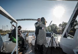 A couple dances relaxed on deck during their Boat trip on the Río Guadalquivir with 6-course menu organized by Fun Ride Sevilla.