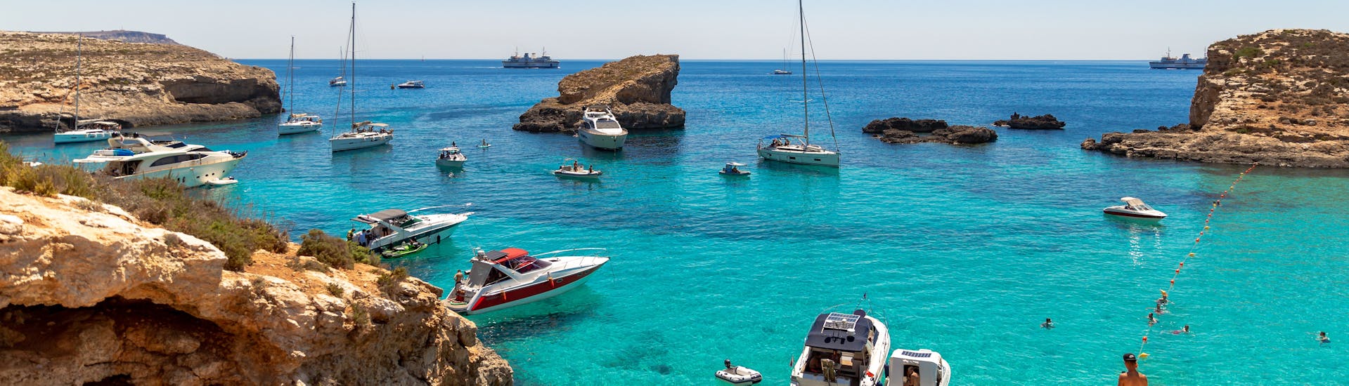 A lot of boats are docked near the coast during the Boat Trip to Comino incl. Blue Lagoon, Caves & St. Paul's Island mit Mermaid Cruises Malta.