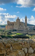 Ein beeindruckendes Gebäude und die umgebende Landschaft während der Bootsfahrt nach Gozo, Comino und den St. Pauls Inseln mit Mermaid Cruises Malta.