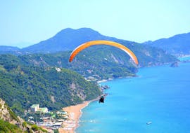 Beim Tandem Paragliding in Korfu gleiten ein Tandempilot von Corfu Paragliding und sein Passagier über das türkisfarbene Wasser des Ionischen Meeres.