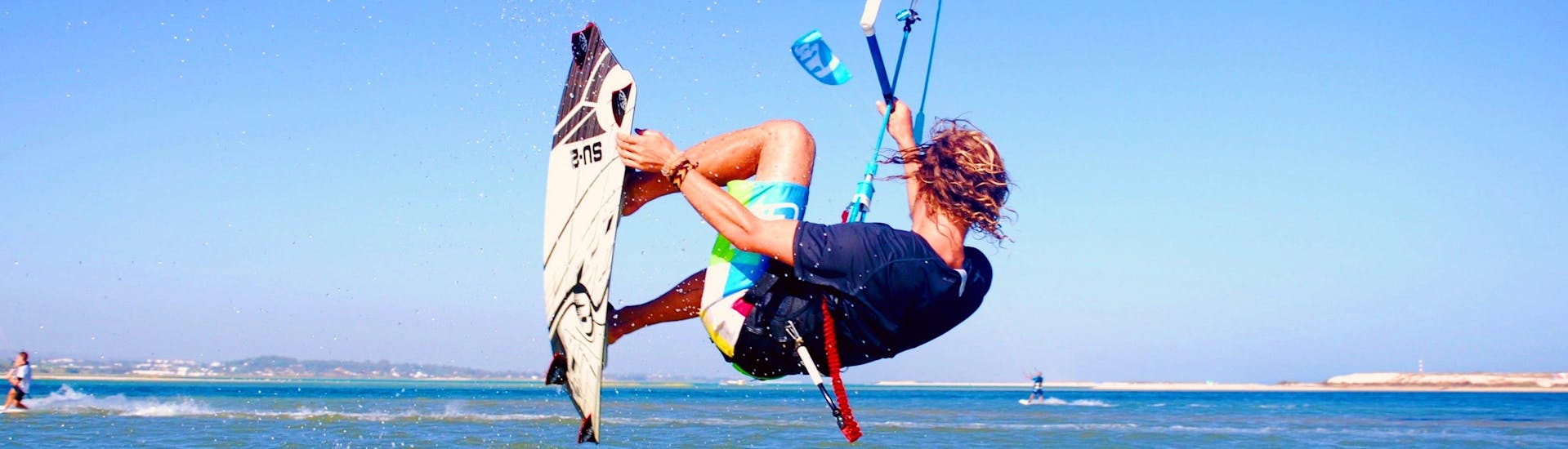 During the Private Kitesurfing Lessons in Fuseta for All Levels with Kite Culture Algarve, an advanced kitesurfer is practicing some jumps on the flat water of the Fuseta Lagoon.
