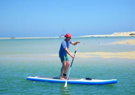 During a Guided SUP Tour in Ria Formosa Natural Park with Kite Culture Algarve, a participant is exploring the turquoise, warm waters of the lagoon.