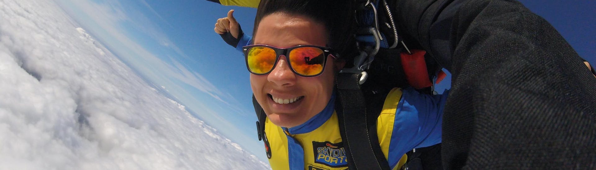 A female skydiving student is seemingly enjoying herself while tandem skydiving in Proença-a-Nova with Skydive Porto.