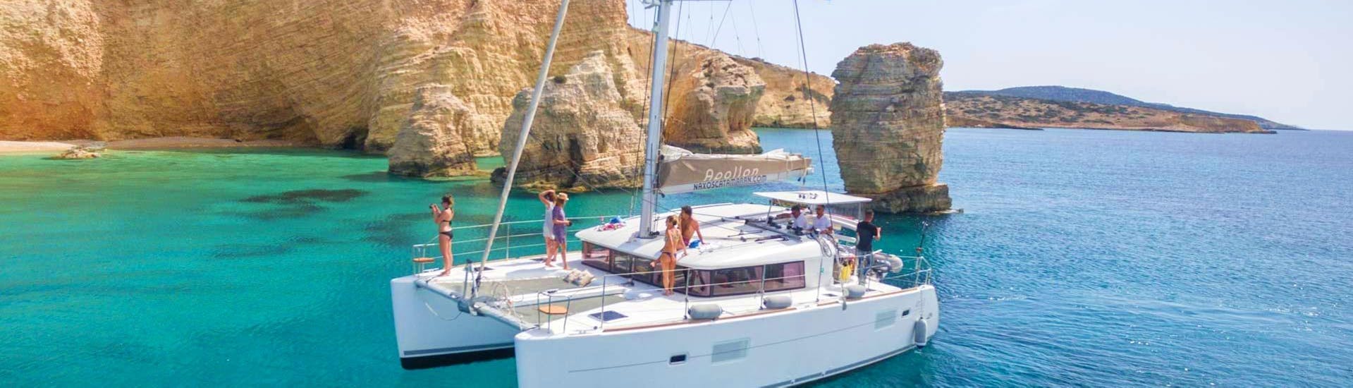 During the Full-Day Sailing Cruise on a Luxury Catamaran from Naxos, the catamaran Apollon from Naxos Catamaran is sailing along the beautiful coast of Paros.