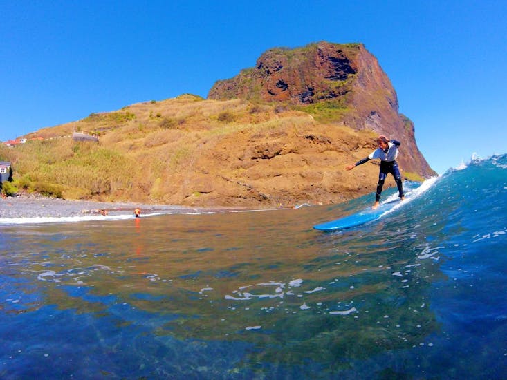 A student learns to surf on the beautiful beach during his Surfing Lessons in Madeira for Beginners and Intermediates with Madeira New Wave.