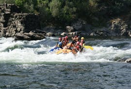 A group of people can be seen paddling across one of the tumultuous rapids while rafting on the Minho River with Melgaço White Water.