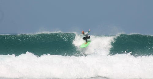Lezioni private di surf sulla Costa Vicentina con pick-up con la Neptunos Surf School Algarve. Un surfista sta surfando alcune delle migliori onde dell'Algarve con la sua guida di surf sulla Costa Vicentina con pick-up della Neptunos Surf School Algarve.