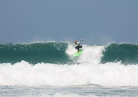 Een surfer surft op enkele van de beste golven in de Algarve met zijn Surfgids aan de Costa Vicentina met ophaalservice van Neptunos Surf School Algarve.