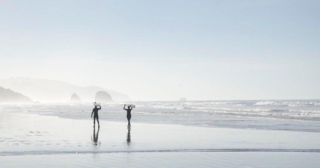2 surfisti che camminano sulla spiaggia durante le lezioni private di surf in Costa Vicentina con pick-up con la Neptunos Surf School Algarve.