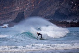 Un surfista está surfeando algunas de las mejores olas del Algarve con su guía de surf en la Costa Vicentina, con recogida, con Neptunos Surf School Algarve.