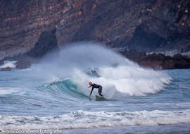 Un surfista sta surfando alcune delle migliori onde dell'Algarve con la sua guida di surf sulla Costa Vicentina con pick-up della Neptunos Surf School Algarve.