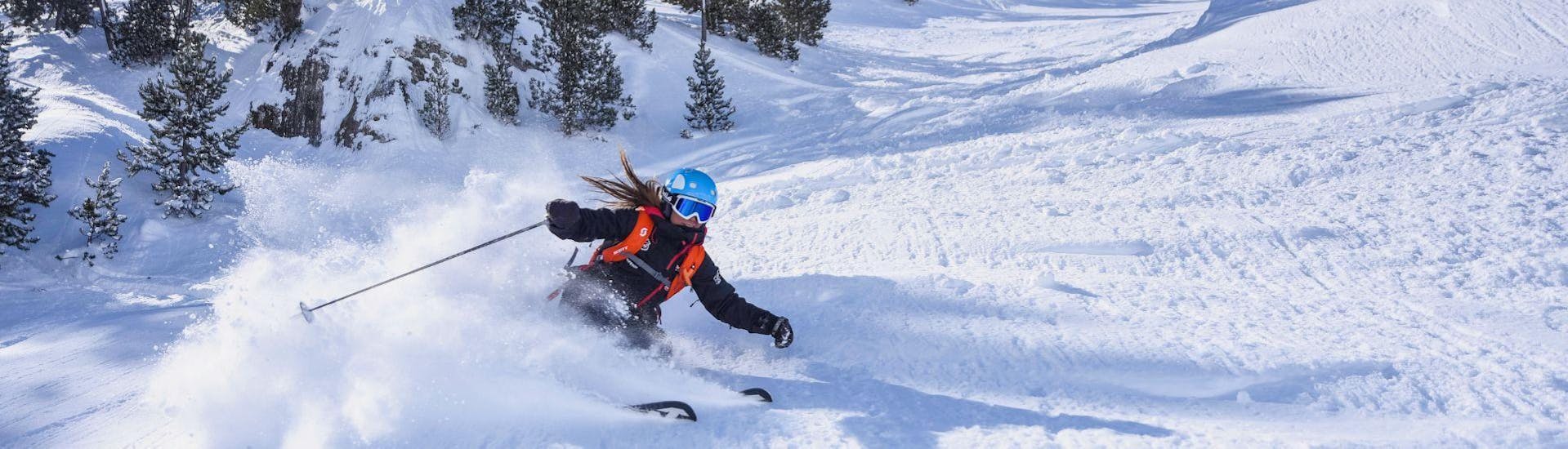 Un moniteur de ski de l'école de ski Sierra Nevada descend les pistes avec élégance et sportivité pendant les cours particuliers de ski pour adultes - tous niveaux.