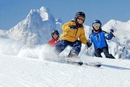 Drei Kinder fahren während ihres privaten Skikurses für Kinder aller Alters- und Leistungsstufen mit der Skischule Pettnau in St. Anton einen Hang hinunter.