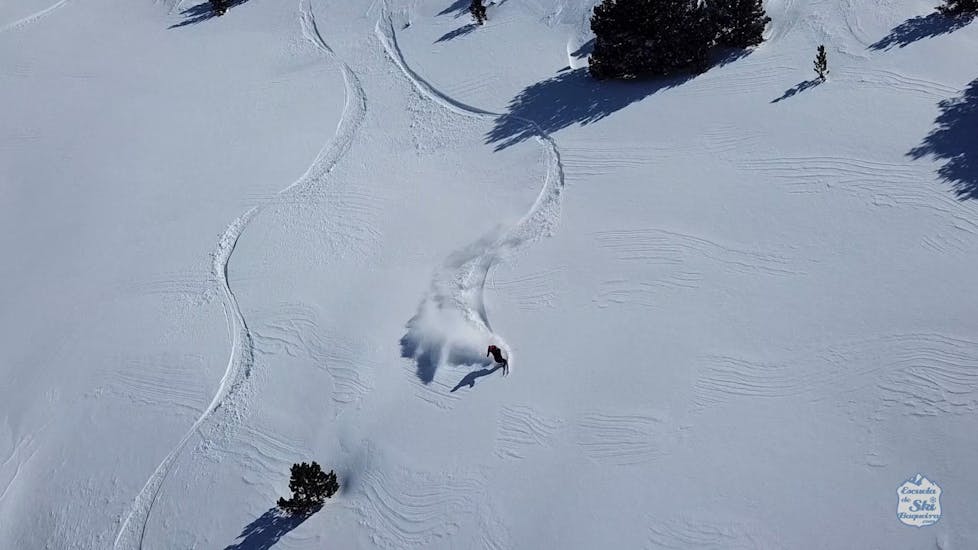 Een skiër geniet van de rit door de diepe sneeuw tijdens de privé off-piste skilessen voor alle niveaus van Escuela Ski Cerler.
