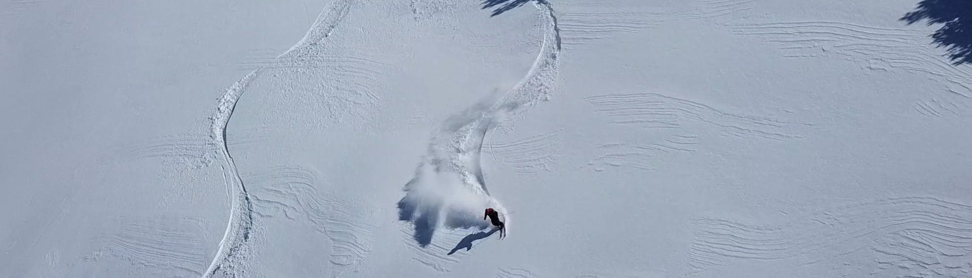 Un esquiador disfruta del paseo por la nieve profunda durante las Clases particulares de Freeride para todos los niveles de la Escuela Ski Cerler.