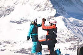 Un bambino e un istruttore si danno il cinque durante le lezioni di sci per bambini (6-11 anni) per tutti i livelli della Scuola di sci Evolution di Zermatt.