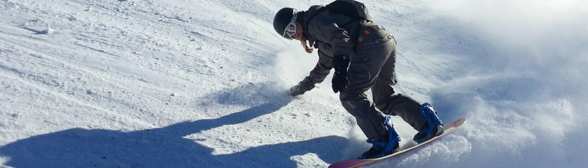 Eine junge Frau übt beim privaten Snowboardkurs für Kinder und Erwachsene mit der Skischule Schwarzeneberg am Bödele ihrer Fertigkeiten beim Snowboarden.