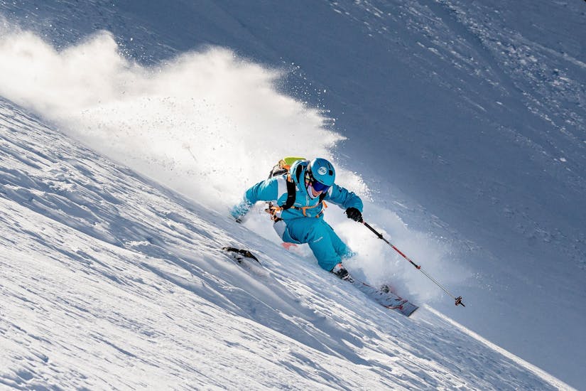 Een skileraar van de skischool ESI Alpe d'Huez - Europese skischool skiet de helling af om het voortouw te nemen tijdens privéskilessen voor volwassenen van alle niveaus - laagseizoen.