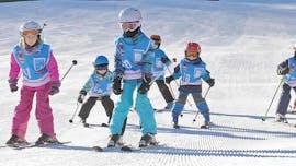 Several young skiers are racing down a freshly prepared ski slope during one of their Kids Ski Lessons (5-16 y.) for Advanced Skiers with Skischule Schaber in Grünberg Obsteig.