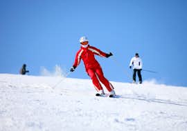 Adult Ski Lessons for Beginners from Skischule Schaber Grünberg-Obsteig A ski instructor from Skischule Schaber in Grünberg Obsteig is skiing downhill while their pupils follow during one of the Adult Ski Lessons for Beginners.