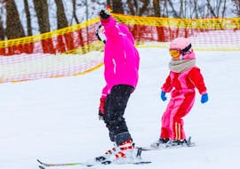 Ein Skilehrer der Skischule Schaber in Grünberg Obsteig zeigt einem kleinen Kind beim Privaten Kinder-Skikurs für alle Levels wie man im Schneepflug fährt.