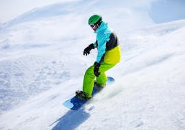 A young man can be seen snowboarding down a freshly prepared slope during his Snowboarding Lessons for Kids & Adults for Beginners with Skischule Schaber in Grünberg Obsteig.