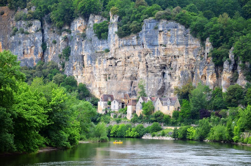 A group of people in a canoe admire the cliffs on their 10 km canoe trip on the cliff path with Canoës Randonnée Dordogne.