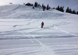 A ski instructor enjoys skiing in deep snow with the Private Ski Touring Guide for All Levels from the Ski School Ingrid Salvenmoser.