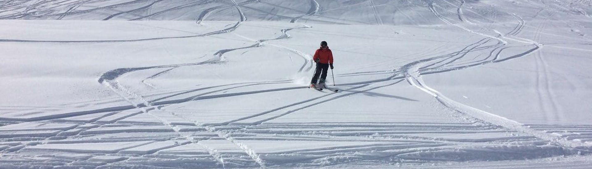 Ein Skfiahrer genießt das Fahren im Tiefschnee während der Privaten Skitour für alle Levels von der Skischule Ingrid Salvenmoser.