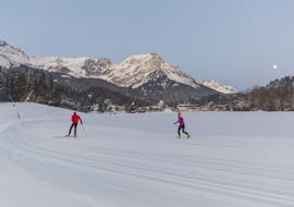 Two cross-country skiers glide through the fresh tracks during thePrivate Cross Country Skiing Lessons for All Levels of Skischule Ingrid Salvenmoser.