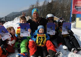 A ski instructor of the Skischule Semmering having fun with the kids in the snow, after the Kids Ski Lessons "Bambini" (3-5 y.) - Half Day - Holidays. 