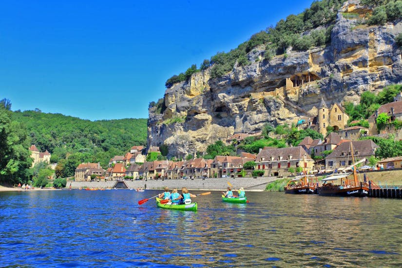 A group of canoes is paddling on the Dordogne River during the 16km journey from Vitrac with Canoë Dordogne.