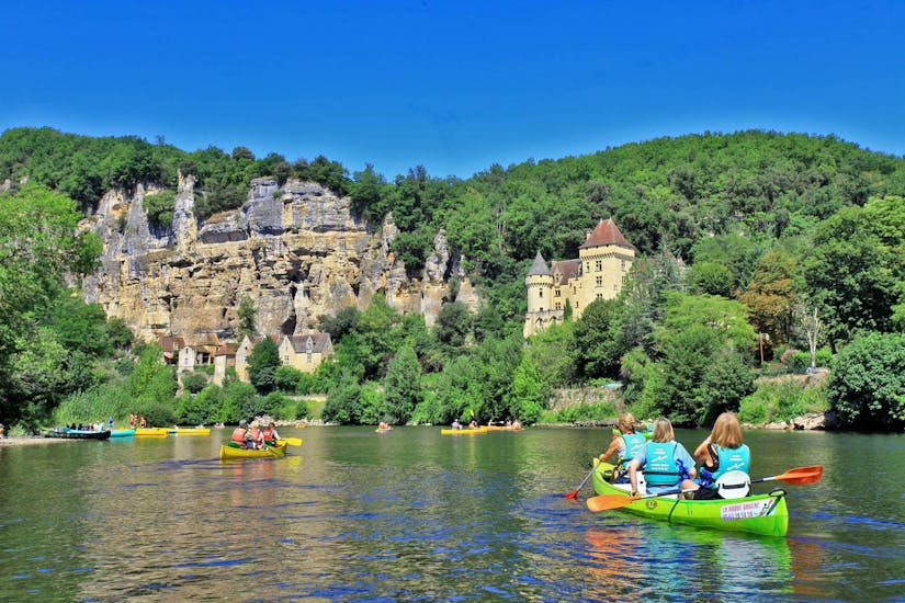A group of people on several canoes on the Dordogne river is contemplating the cliffs during the 16km trip from Carsac with Canoë Dordogne.