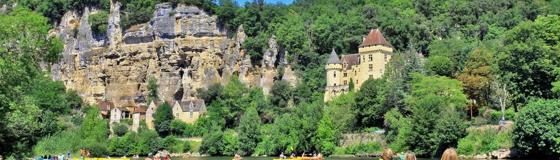 Een groep vrienden in verschillende kano's op de Dordogne overpeinst de kliffen tijdens de 16 km lange tocht van Carsac met Canoë Dordogne.