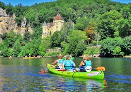 Un gruppo di amici in canoa sul fiume Dordogna sta ammirando un castello fortificato durante il viaggio di 25 km da Carsac con Canoë Dordogne.