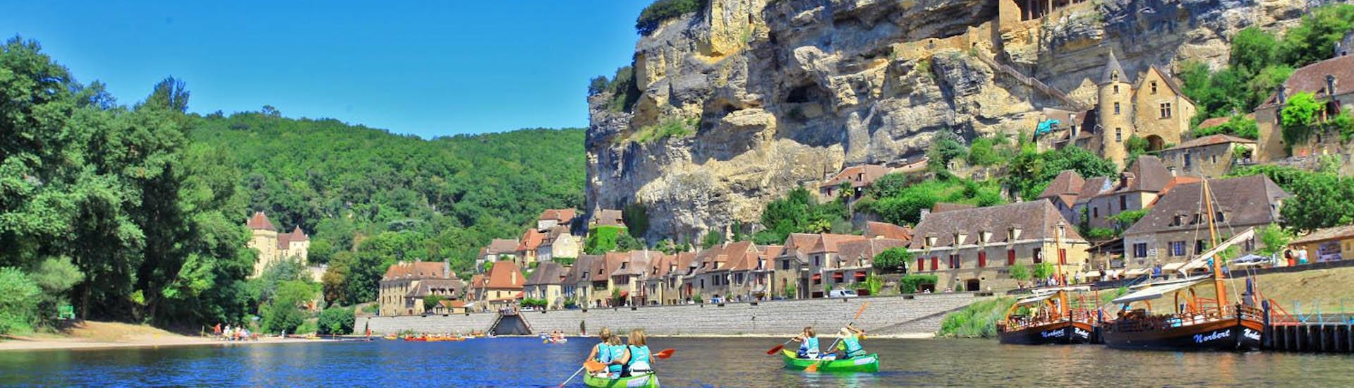 A group of canoes on the Dordogne River is admiring the landscapes during the 25km trip from Carsac with Canoë Dordogne.
