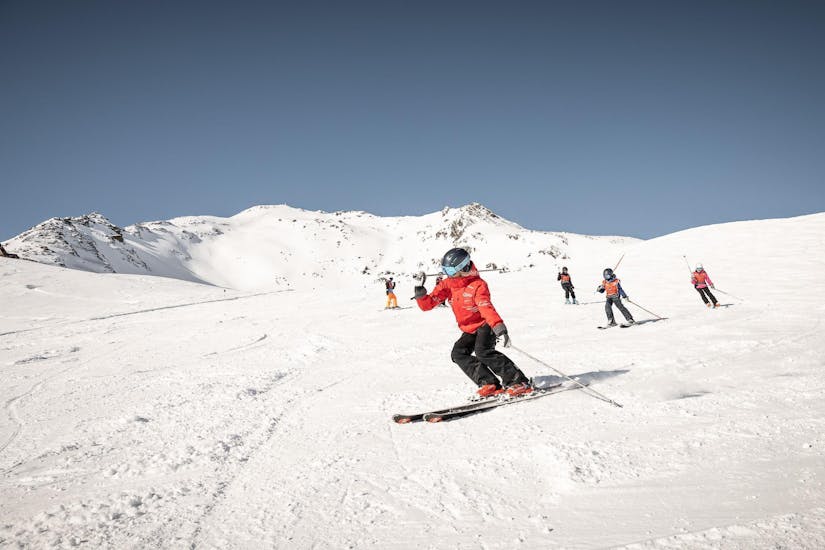Een skilerares van Ski- und Snowboardschule Vacancia legt een activiteit uit tijdens de cursus Skilessen kinderen "All-Inclusive" (4-8 jaar) - Alle niveaus.