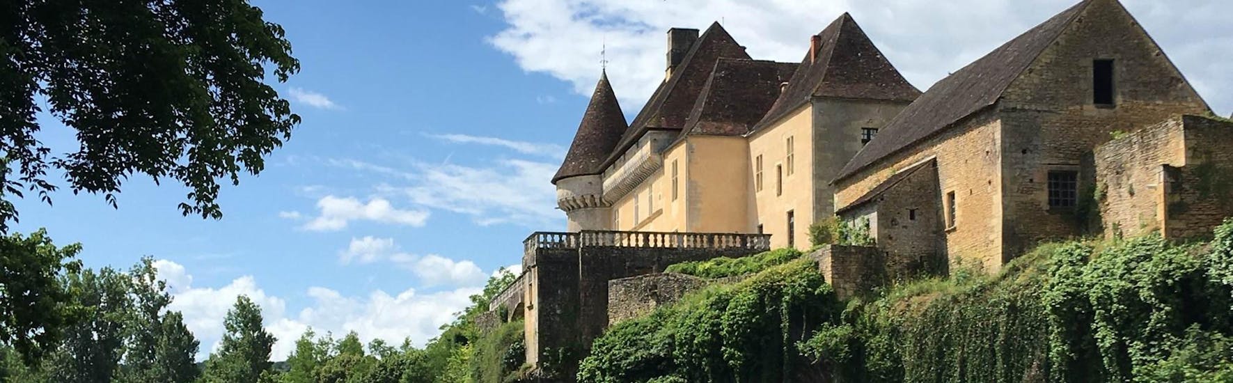 Des touristes comtemplent le château de Belcaire sur la Vézère en canoë lors de la sortie des 3 château de 8km avec Canoë Family.