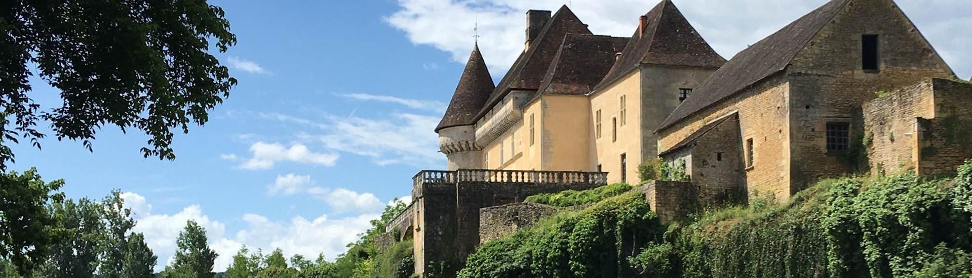 Touristen betrachten das Schloss von Belcaire auf der Vézère im Kanu auf der 8km langen Burgenroute mit Canoë Family.