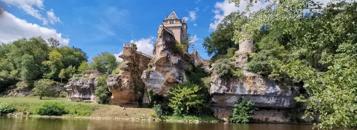 Des touristes contemplent un château depuis la Vézère en canoë lors de la sortie sportive de 17km avec Canoë Family.
