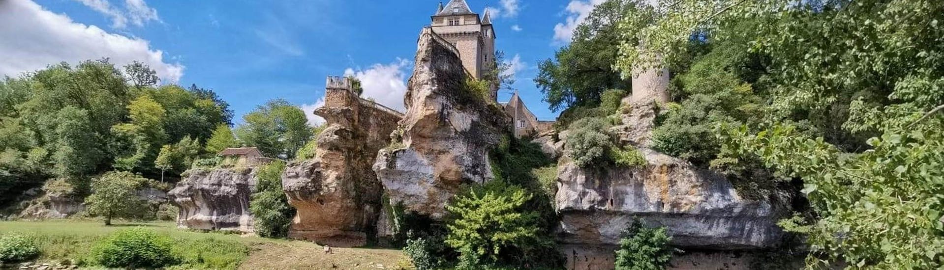 Des touristes contemplent un château depuis la Vézère en canoë lors de la sortie sportive de 17km avec Canoë Family.