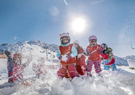 Eine Gruppe junger Skifahrer hat bei einer Schneeballschlacht im Bambini Kinder-Skikurs (3-5 J.) für Anfänger der Skischule Schruns eine Menge Spaß.