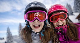 Due sorelle si divertono sulla neve durante le lezioni private di sci per bambini (dai 3 anni) di tutti i livelli con la Skischule Tannberg Lech.