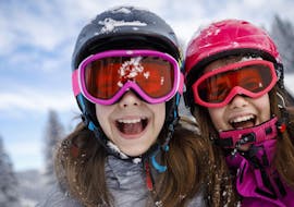 Two sisters are having fun in the snow during their Private Ski Lessons for Kids (from 3 y.) of All Levels with Skischule Tannberg Lech.