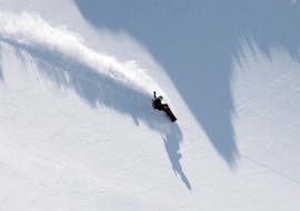 A snowboarder is practicing new techniques on the slopes during the Private Snowboarding Lessons for Kids & Adults of All Levels with Skischule Tannberg Lech.